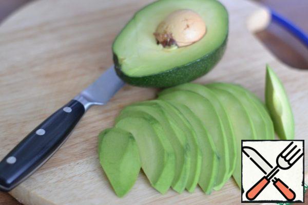 Peel the avocado and cut it into slices.