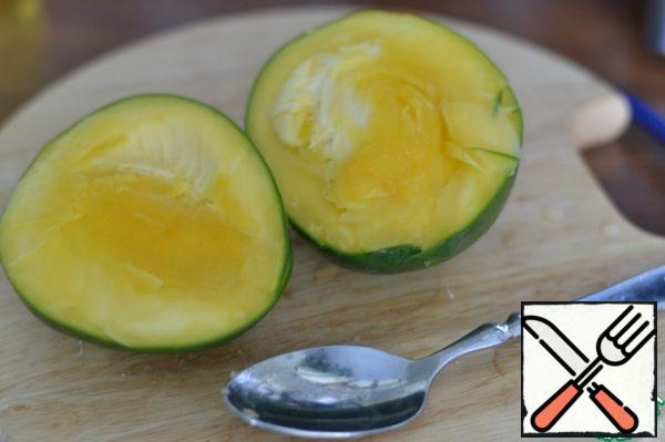 Using a tablespoon, divide the mango into two parts.
Cut into slices.