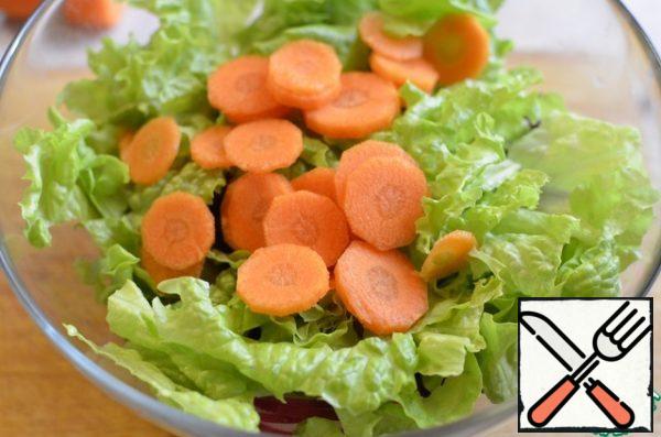 Lettuce leaves, peeled and sliced carrots. season with salt and olive oil. Stir. Divide the salad into 2 parts.