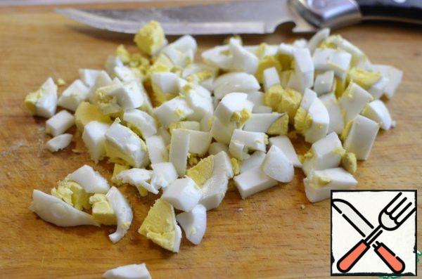 In one part, add a boiled egg cut into cubes. put the salad in plates of red cabbage.