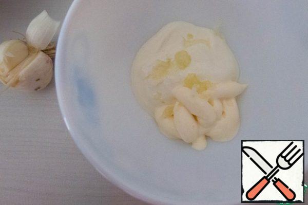 Prepare the dressing - 50/50 sour cream and mayonnaise, young squeezed garlic, mix thoroughly.