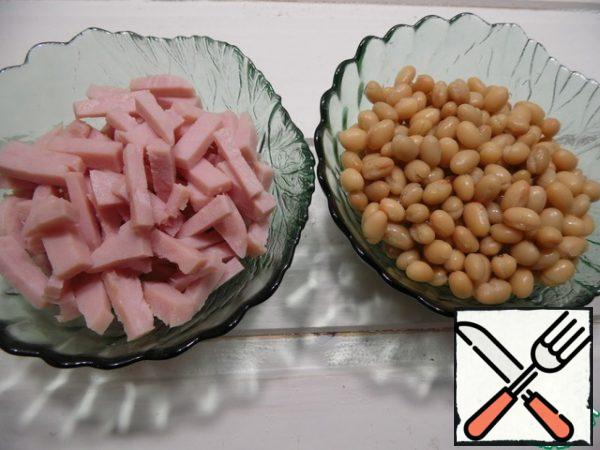 drain the liquid from the beans, cut the ham into cubes.