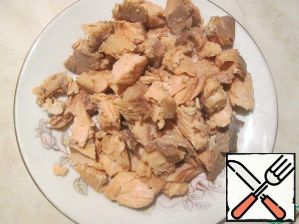 In the original recipe, the fish fillet should be boiled for 10-12 minutes, then cooled. So, we disassemble the fish prepared in any way into small pieces, remove the bones and skin.