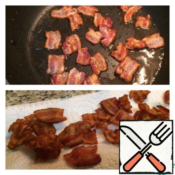 Cut the bacon into pieces of about 2 cm, fry in a dry pan.
Transfer to a paper towel, remove excess fat.
Boil the eggs.