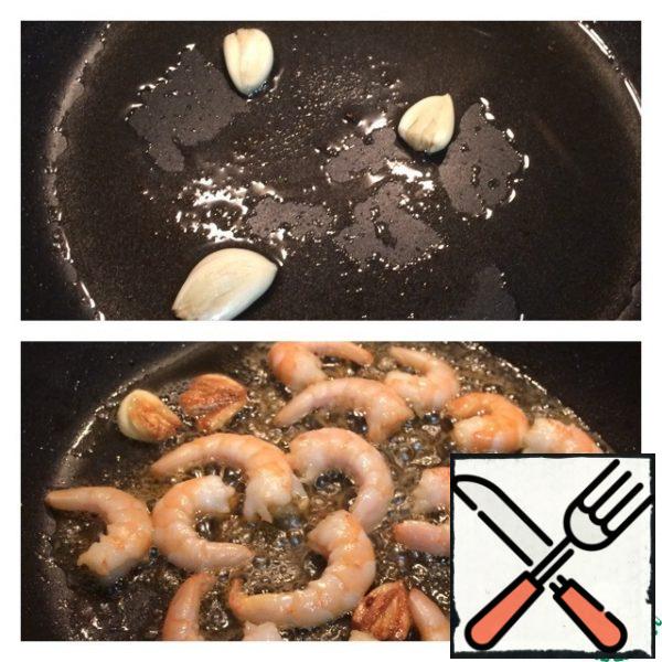 In the same pan, fry the crushed garlic cloves first, then the peeled shrimp, removing the garlic, literally 1 minute.