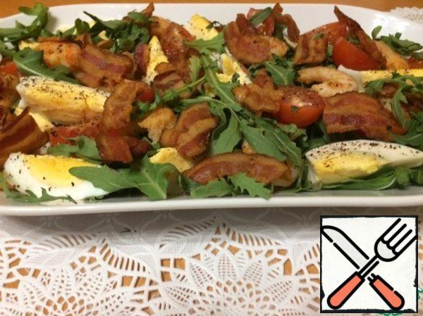 That's all, you can collect the salad.
Place the arugula, halved cherry tomatoes, shrimp, eggs, cut into wedges, and top the bacon. Fill immediately before eating, so that the arugula does not wither.