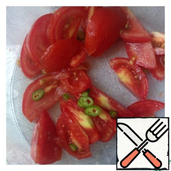 Tomatoes cut into half slices. Do not peel the hot pepper from the seeds and cut it into small circles.