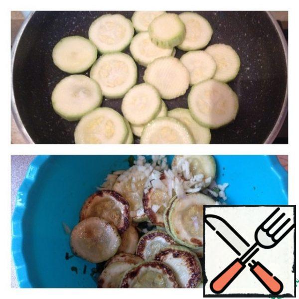 Wash the zucchini and cut into rings. Fry on both sides in vegetable oil. Still hot, put our zucchini on the prepared greens along with the oil from roasting. Finely chop the garlic and place it on the zucchini.