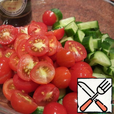 Cherry tomatoes cut in half, cut cucumbers into circles or halves, depending on the size. Put in a salad bowl.