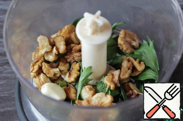 In the chopper, add walnuts, coarsely chopped herbs (coriander can be together with the stems, and Basil and parsley-only leaves) and chopped garlic cloves.