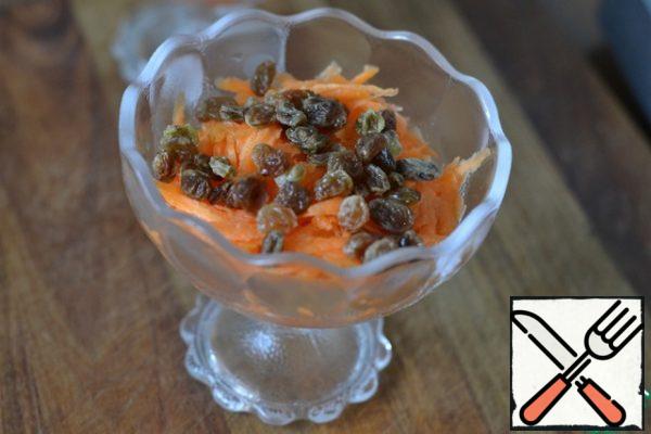 Drain the water from the raisins.
Spread the raisins on the carrots.