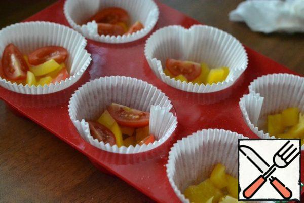 Finely chop the bell pepper, cherry tomatoes cut in half.
Put a little pepper and cherry tomatoes on the bottom of the molds.
Season with salt and pepper.