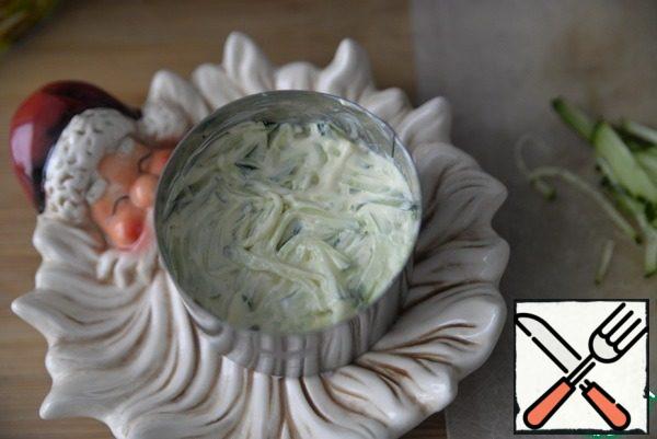 Grate the cucumber, put the ham on top and grease with mayonnaise.