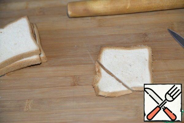 For a more presentable presentation and for a buffet table, I suggest serving this salad in tartlets made of toast bread.
We take toast bread. If it is not quite fresh, I recommend warming it up in the microwave for 10 seconds. Roll out the bread toast with a rolling pin. Cut off the corner.