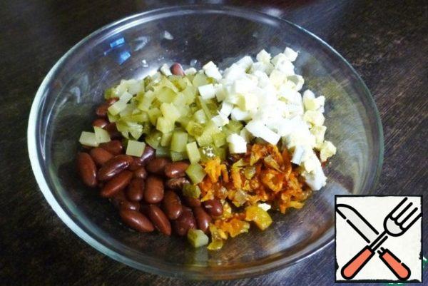 Cut the pickles and boiled eggs into cubes and add to the salad bowl.