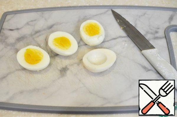 Boil the eggs hard-boiled. Cut three eggs in half lengthwise and remove the yolks.
