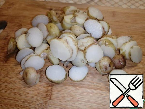 Cut the potatoes into circles.
I don't peel new potatoes, you can peel them. Pour into a deep bowl.