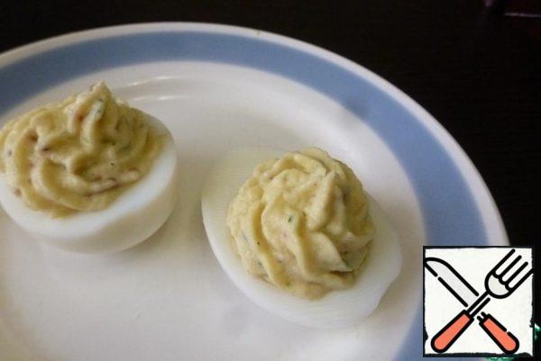 Fill the cooking syringe with applesauce and gently squeeze into the egg halves.