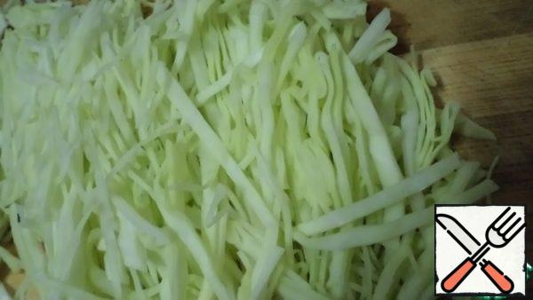 Cut the white cabbage into thin strips and put it in a saucepan or frying pan until half cooked.