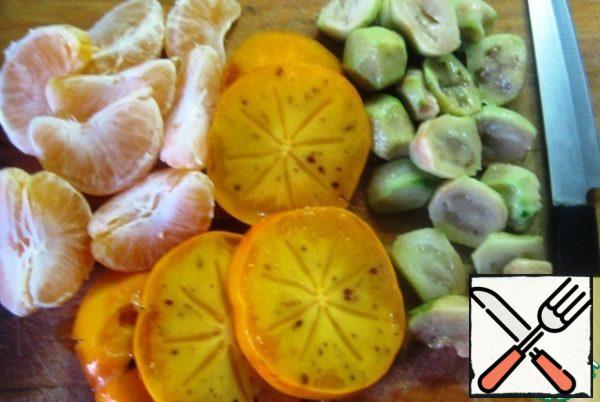 Thinly slice the skin from the feijoa berries, peel and slice the tangerine, and cut the persimmon into pieces.