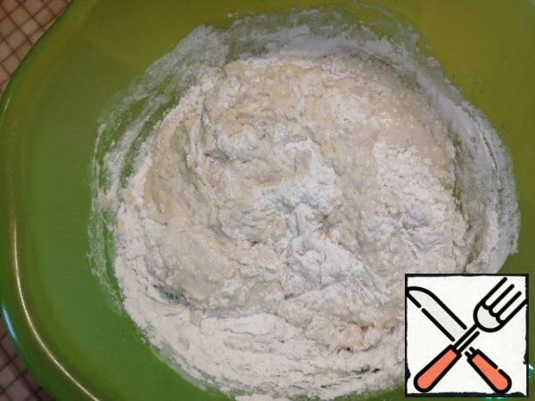 Add the sifted flour in parts and knead the dough.