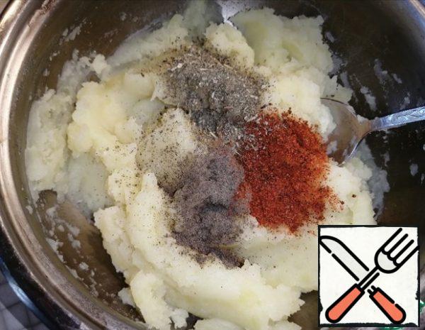 Mash the potatoes. Salt to taste. Add the pepper, paprika or seasoning, herbes de Provence. Stir well.