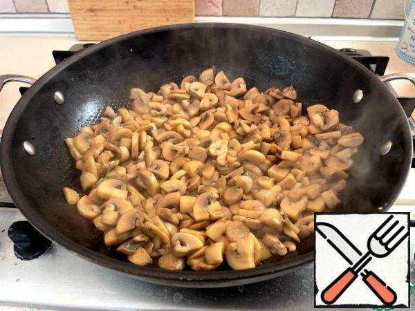 Mushrooms cut into plates 3-4 mm thick and lightly fry in a frying pan (I have a wok) in vegetable oil. I had 1 kg of mushrooms here, but after roasting, I selected half as a preparation for the future.