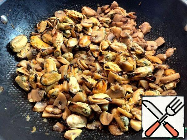 Add the mussels to the mushrooms and continue cooking over medium heat. Then add the fried onions to them.