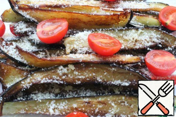 Spread the eggplant on the dish in layers, sprinkling each layer with salt and grated cheese. If you use feta, be careful with salt!
Spread the cherry cut into halves.