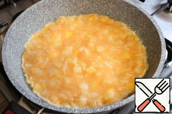 In a preheated clean frying pan, pour 1 tbsp of sunflower oil. Spread half of the egg-potato mixture. Fry on a slightly lower-than-average heat for 1 minute to set the base.