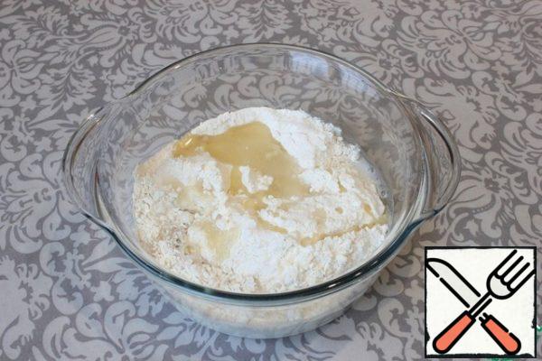 In a large bowl, mix the flour with fast-acting dry yeast. Add sugar and salt. Stir.
I pour in warm water and warm milk. I add sunflower oil.