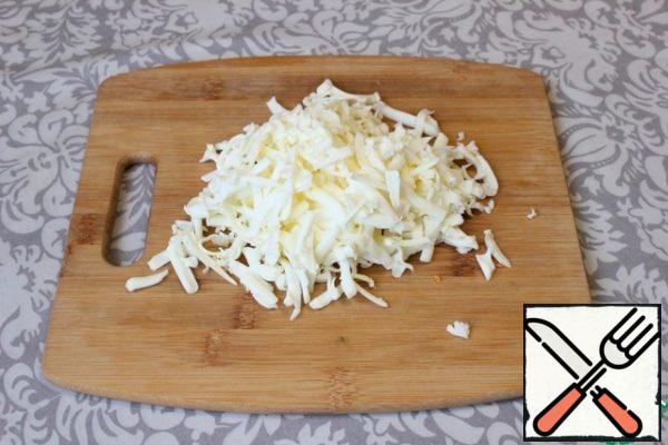 I grate the processed cheese on a large grater.