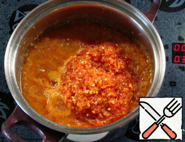 Pass the bell pepper, garlic and hot pepper through a meat grinder or grind in a blender and add to the tomato sauce. Stir and cook for 10-15 minutes.
