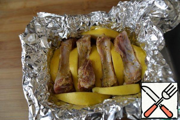 In a convenient baking form, put in two layers of foil. Put the marinated pork. If you have a whole piece with cuts, just insert the quince into the cuts. In my case, put the quince between the pieces of pork and around the edges.