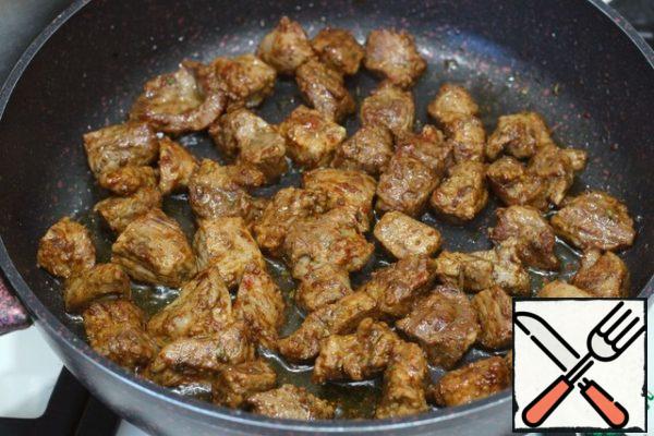 Stir-fry the beef for 15-20 minutes. Everything will depend on the size of the pieces, we need to get a Golden crust, we will bring the dish to readiness in the oven.