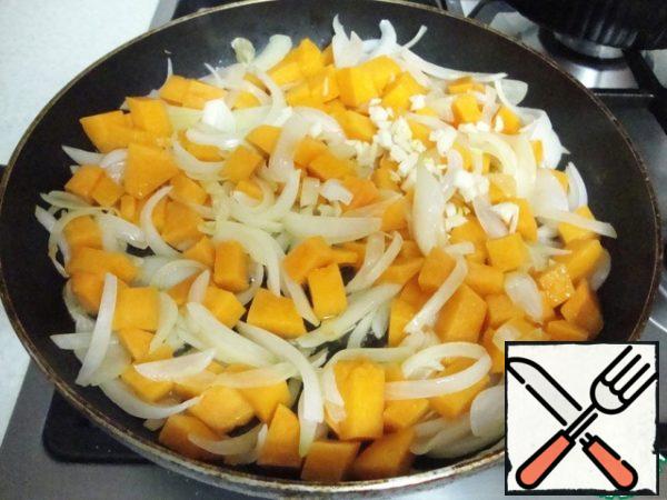 Fry the onion over medium heat for 3-4 minutes, then add the pumpkin and crushed garlic.
Fry stirring with a spatula for about 8-10 minutes until the pumpkin is ready.
