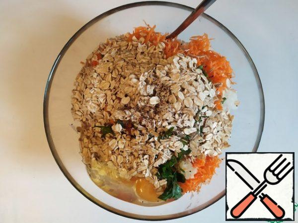 It is important to understand that because of the oat flakes, these meatballs will have a somewhat specific taste, which is called healthy. But, further on the recipe, we will have two options. Or fry them in oil and lower the degree of health, for the sake of taste. Or continue your line and bake in the oven. Grate the carrots, finely chop the onion and parsley and mix all the ingredients.