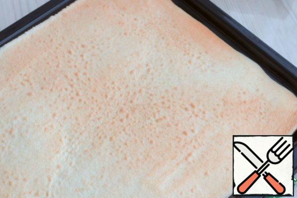 Cover the baking sheet with a silicone Mat. Put the sponge dough on a silicone Mat and smooth it out. Send the baking sheet to the oven preheated to 180C. Bake for 8-10 minutes. In any case, you need to check the readiness through the viewing window of your oven. The finished sponge cake should have a light cream color.