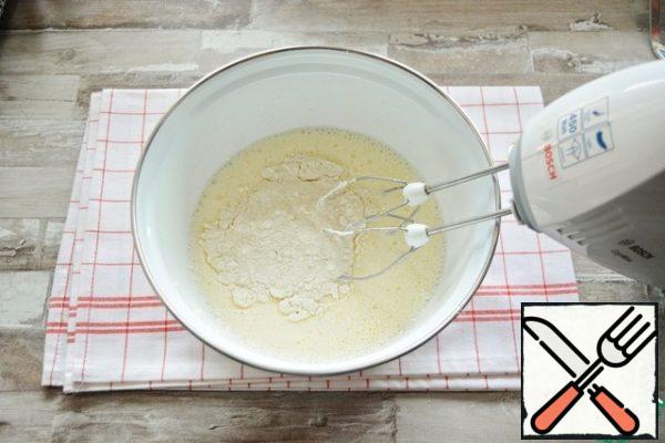 Gradually, at low speed of the mixer, add the sifted flour with baking powder.