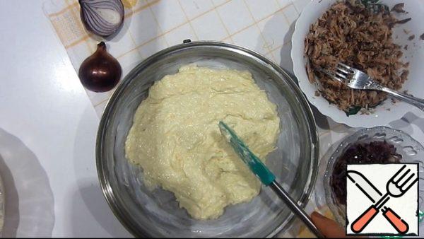 In a form with a diameter of 24 cm, spread half of the dough. Then chopped tuna and fried onions. Spread the remaining dough.