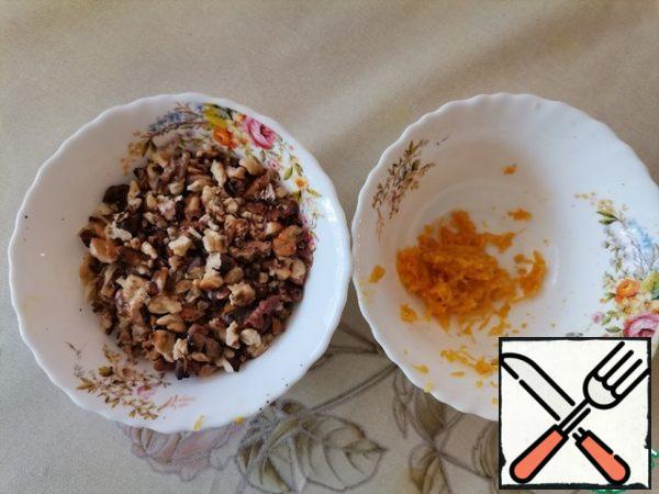 Walnuts are fried and not very finely chopped. Remove the zest from the orange.