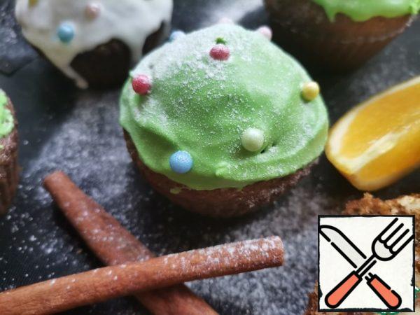 On the cooled muffins to apply the icing and decorate with candy sprinkles in the form of balls. These are the "Christmas trees" we get.