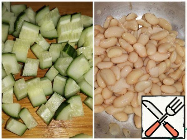 Cut the cucumber into medium cubes. Put the beans in a colander and rinse with cold boiled water.