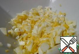 Hard-boiled eggs. Peel the boiled eggs from the shell and also cut into cubes.