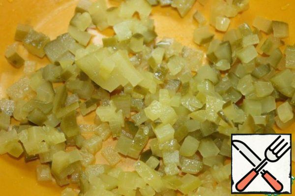 Drain the brine from the jar, get the mushrooms and cut the pears. Send to the fillet and egg. Peel the pickles. Cut into cubes as well.