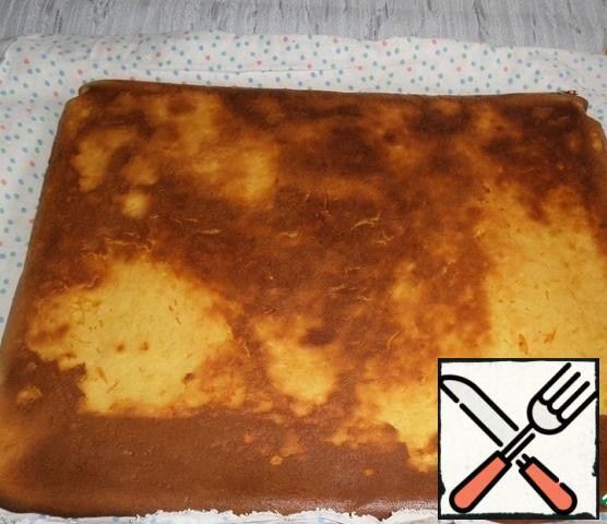Take the baked carrot cake out of the oven and turn the baking sheet on a kitchen x/b towel. Remove the parchment / Mat.