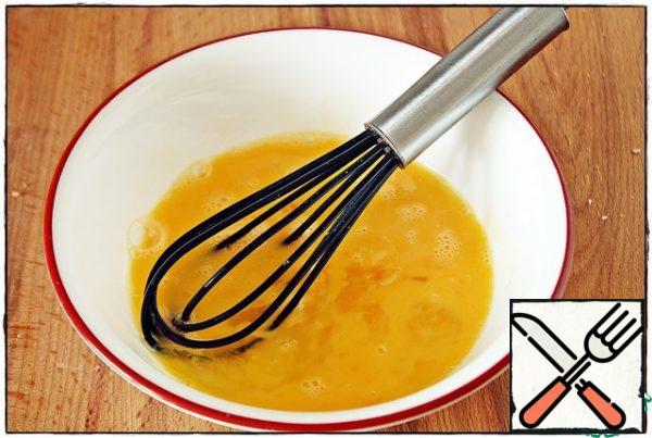 First of all, put the pan on medium heat, then break two eggs into a bowl, add salt and stir.
