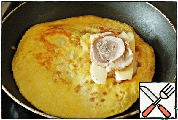 After the bread is laid, turn the spatula to the other side and again press the omelet to the bread... On top of one slice of bread (which is under the omelet) we put a meat yummy, then a slice of cheese and again cover with a meat product...