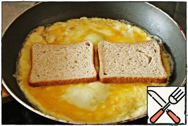 Option one: when the omelet is picked up, put two slices of bread on top and press it slightly, it should stick into the omelet. You can take absolutely any bread that you like. Personally, for such recipes, I keep a toaster seeding in the freezer and take it out as needed...