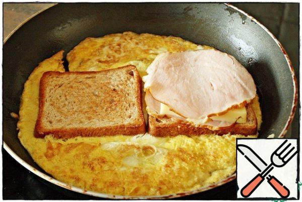Then turn it over again, put a piece of meat (sausage) on one toast, then a slice of cheese and cover with a piece of meat.